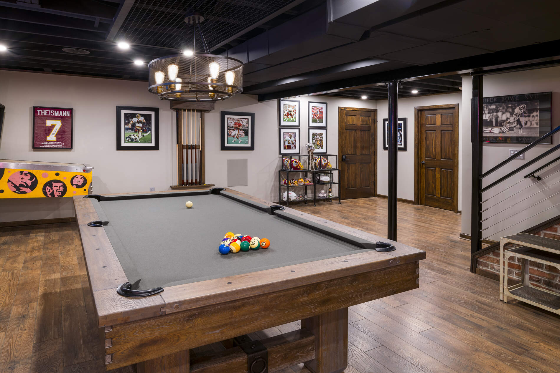 Basement game room with pool table, sports memorabilia, and wood floors in Delaware County, PA