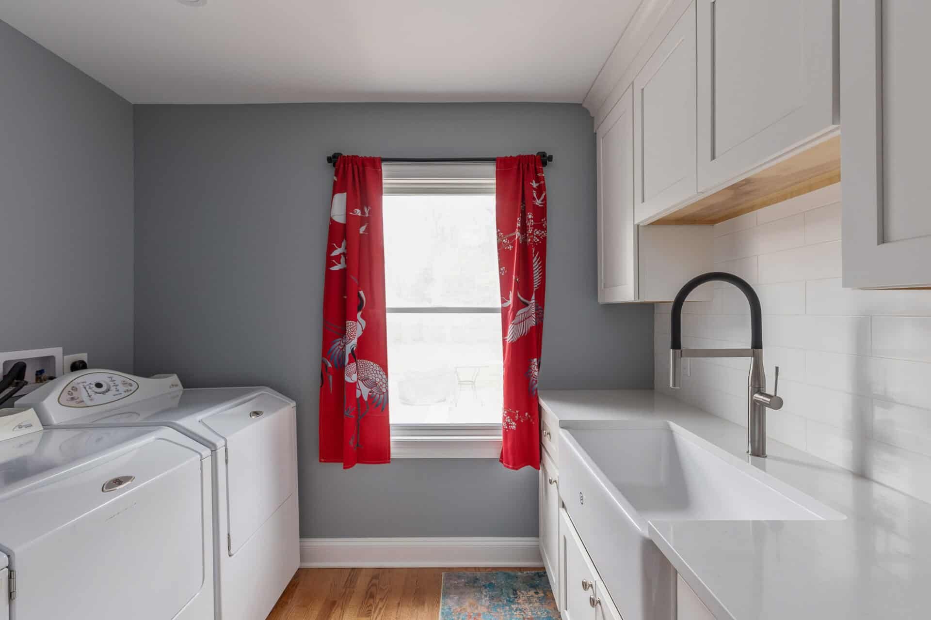 Laundry room featuring appliances with soaking sink and storage cabinetry