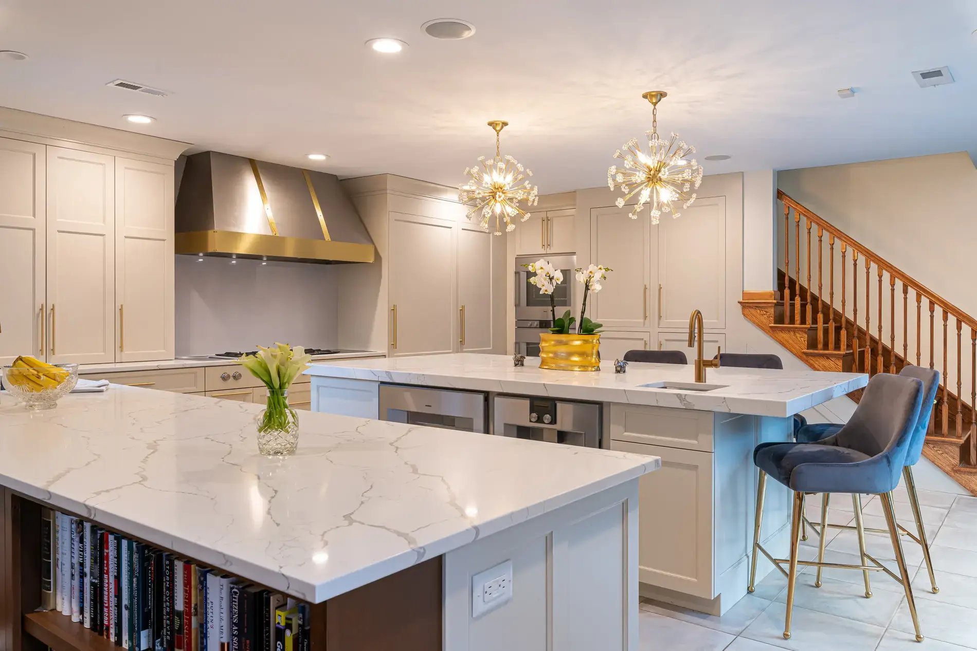 Modern kitchen with marble island, gold fixtures, pendant lights, and bar seating in Delaware County, PA