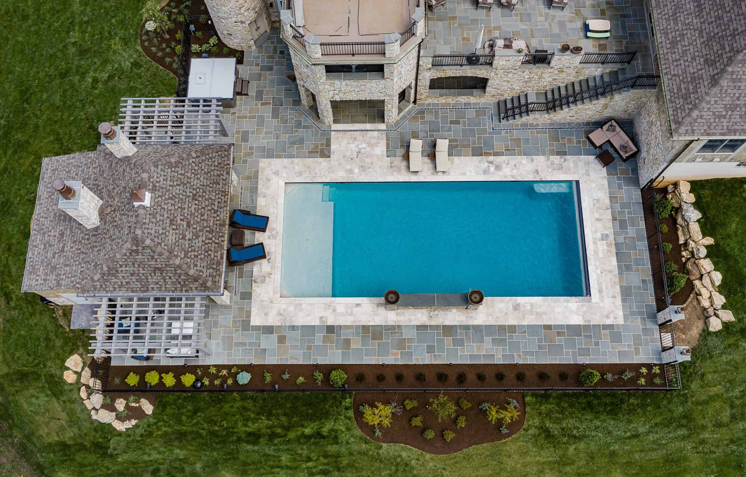 backyard oasis with hardscape custom pool area, pergola and outdoor entertainment space and landscaping 