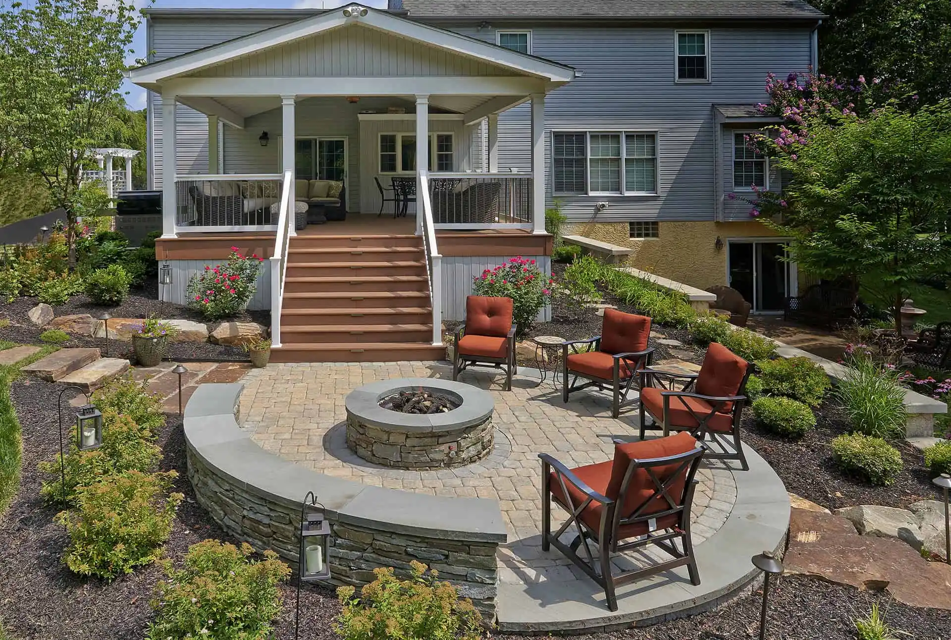 A stone fire pit surrounded by a bench in a cozy backyard setting.